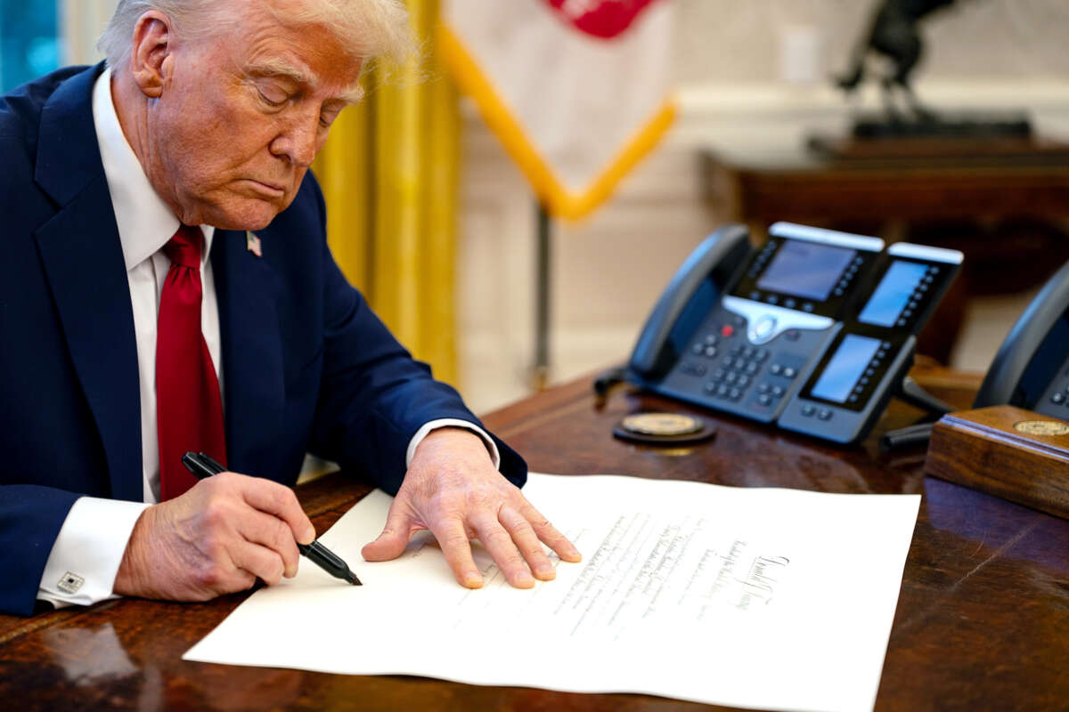 Donald Trump signs a document