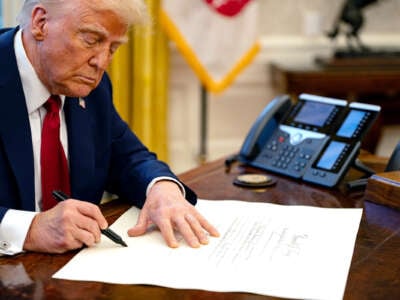 Donald Trump signs a document