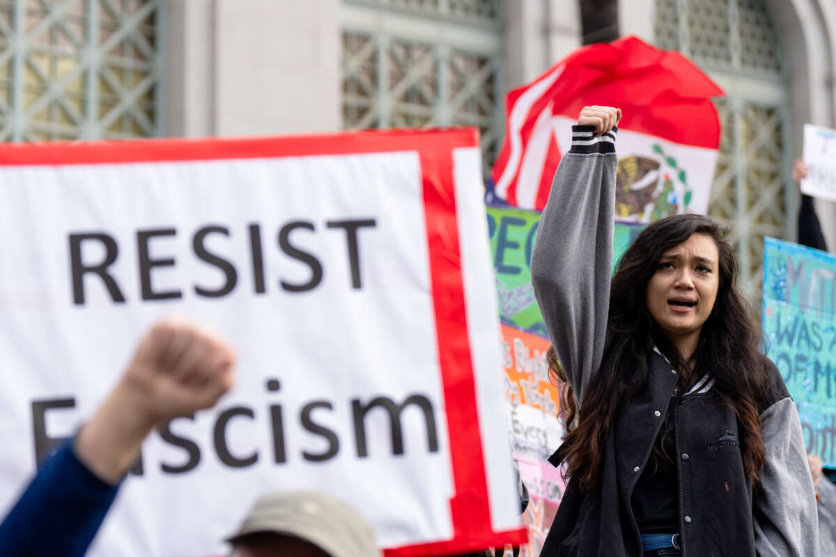 A girl raises her fist as she participates in a protest