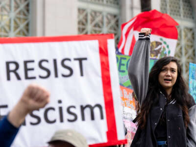 A girl raises her fist as she participates in a protest