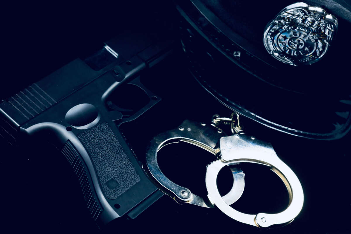 A police officer's hat, handcuffs and gun.