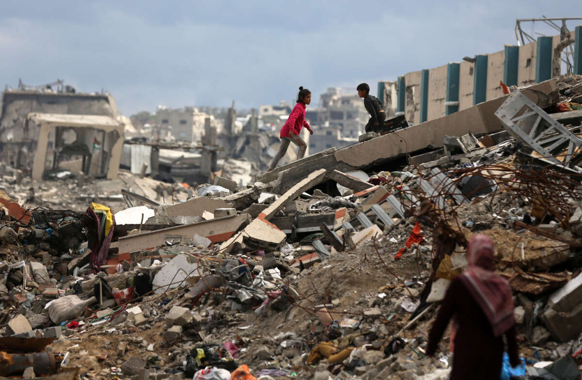 Palestinians walk past tents lining the streets amid the rubble of destroyed buildings in Jabalia, in the northern Gaza Strip, on February 21, 2025.