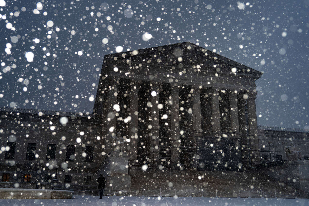 A person stands on the plaza of the Supreme Court as snow falls on February 11, 2025, in Washington, D.C.