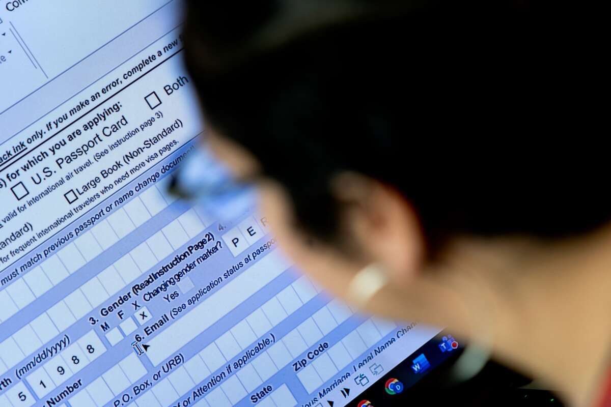 A person begins the process of filling out a passport application with an X gender marker, at their home in Alexandria, Virginia, on April 11, 2022.