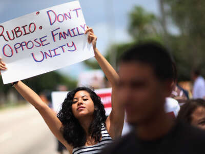 Mariana Rivas holds a sign reading, "Rubio: Don't Oppose Family Unity," as she joins with others in front of then-Sen. Marco Rubio's office on May 22, 2013, in Doral, Florida. The protesters were asking Rubio to stop opposing the inclusion of lesbian, gay, bisexual and transgender families in the Senate’s comprehensive immigration reform bill.