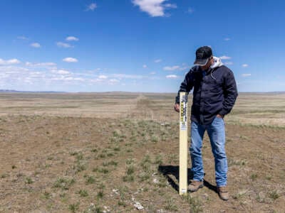 Carter County rancher Mike Hansen stands next to Denbury's carbon pipeline on April 22, 2021, on his Bureau of Land Management (BLM) allotment in Hammond, Montana, part of the 110,000 acres of BLM land where the Snowy River carbon sequestration project has been proposed. Hansen is concerned about the impacts of the project and safety hazards associated with it.