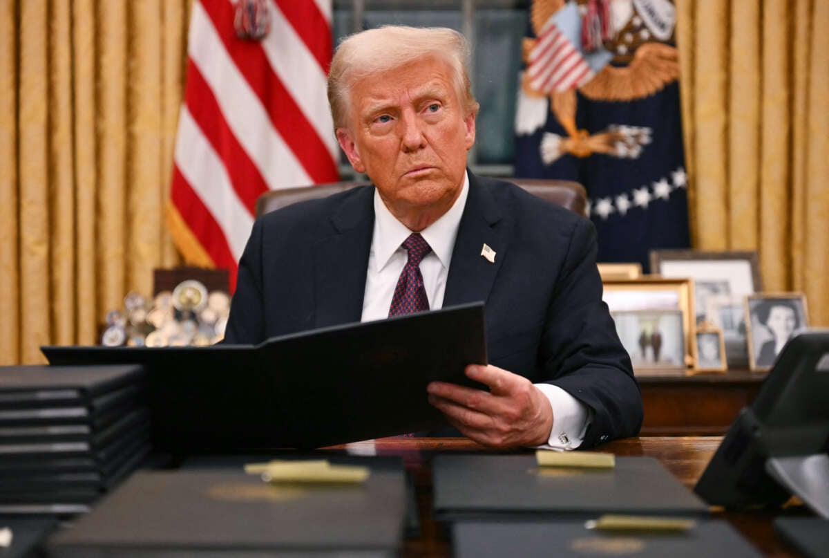 Donald Trump signs an executive order for pardons on January 6 insurrectionists in the Oval Office of the White House in Washington, D.C., on January 20, 2025.