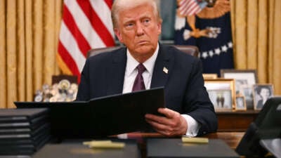 Donald Trump signs an executive order for pardons on January 6 insurrectionists in the Oval Office of the White House in Washington, D.C., on January 20, 2025.