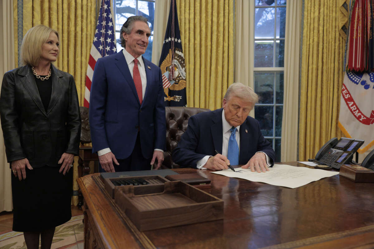 U.S. President Donald Trump signs Interior Secretary Doug Burghum's commission with Burgum and his wife Kathryn Burgum in the Oval Office on January 31, 2025 in Washington, DC. Trump spoke to reporters about tariffs against China, Canada and Mexico.