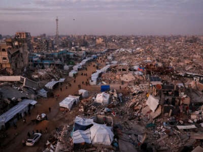 Palestinians walk past tents lining the streets amid the rubble of destroyed buildings in Jabalia, in the northern Gaza Strip, on February 18, 2025.