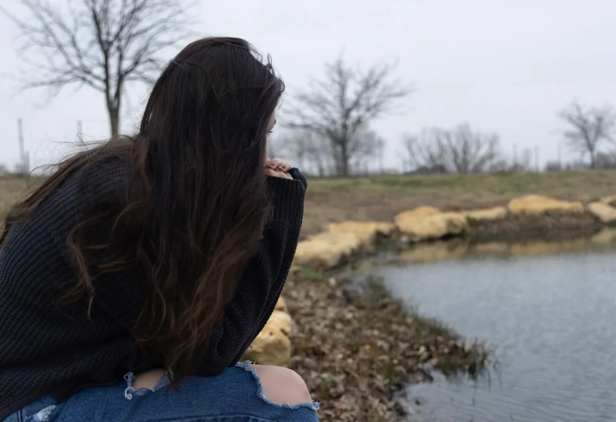 A North Texas woman, shown here gazing out at a small pond near her home in early February 2025, is afraid to discuss her abortion with her mental health therapist for fear she’ll be reported to authorities under Texas’ stringent abortion laws. The woman asked not to be identified for fear of repercussions.