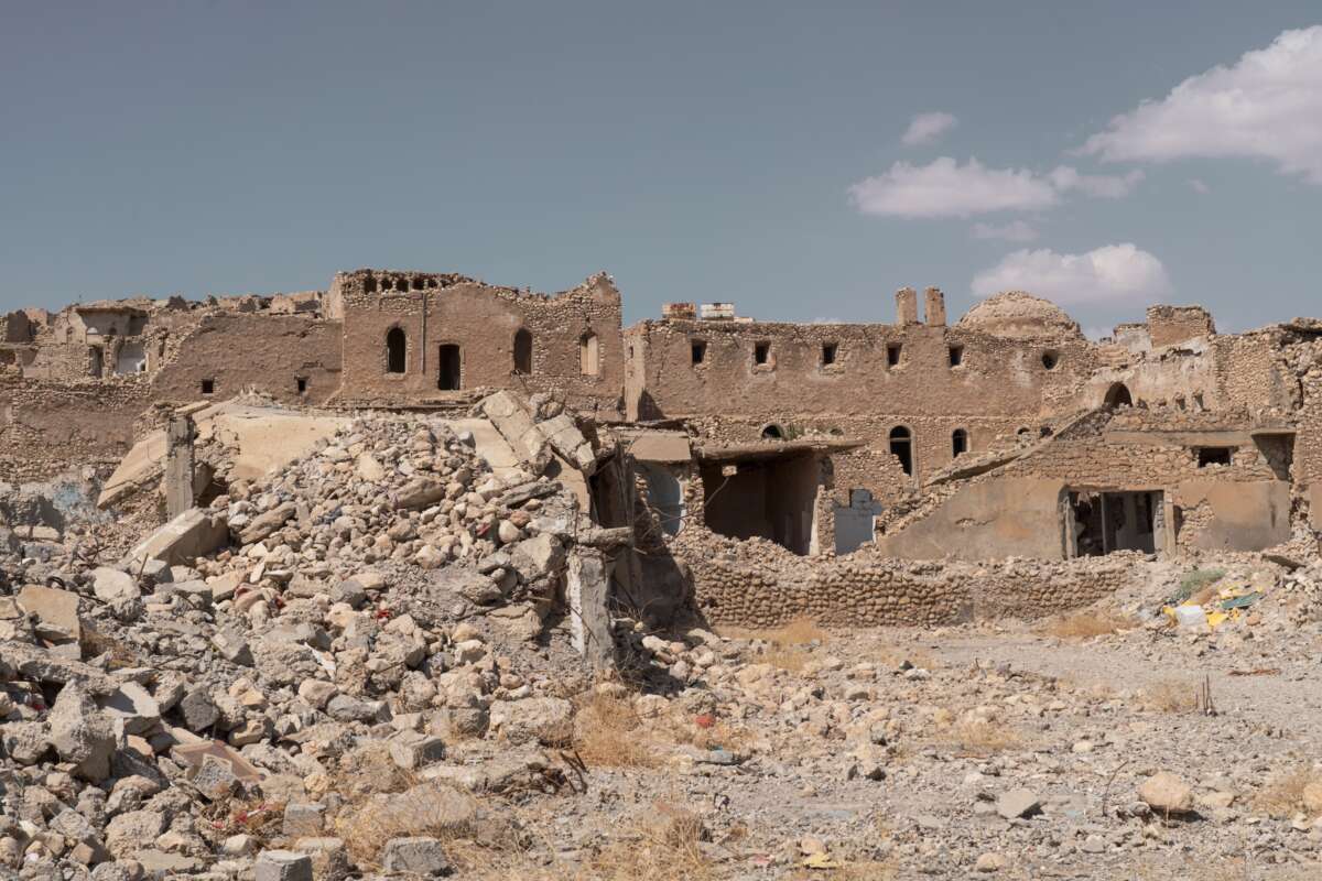 The shell of a building stands out against rubble and toppled brick.