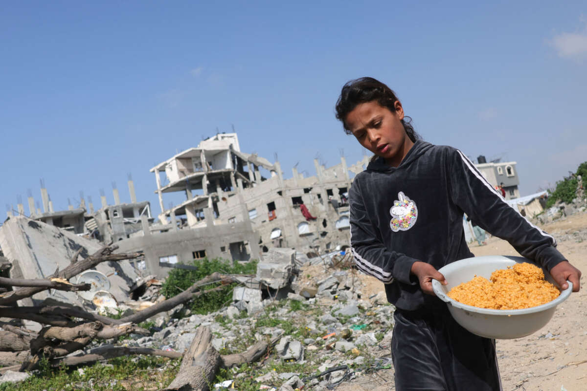 A Palestinian girl carries a food ration back to her family in Jabalia in the northern Gaza Strip on February 17, 2025.