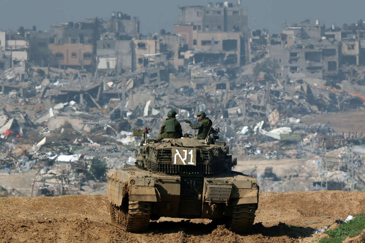 A picture taken from a position in southern Israel along the border with the Gaza Strip shows an Israeli tank rolling along the fence, on January 19, 2024.