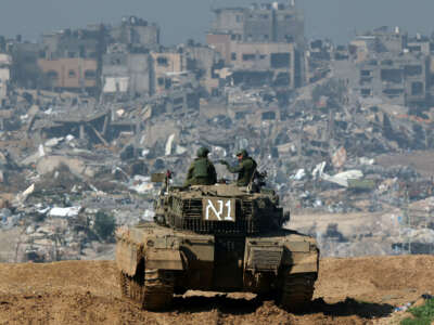 A picture taken from a position in southern Israel along the border with the Gaza Strip shows an Israeli tank rolling along the fence, on January 19, 2024.