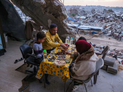 Tamer Hassan al-Shafai eats an iftar meal, the breaking of the fast, with his family in their destroyed house amid the rubble of buildings in Beit Lahia in the northern Gaza Strip on March 4, 2025, during the Muslim holy fasting month of Ramadan.