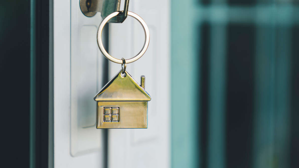 House model and key in house door.