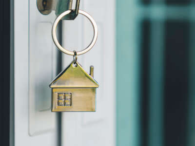 House model and key in house door.