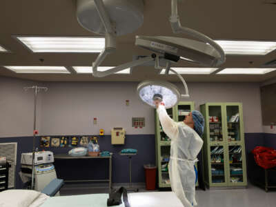 A medical worker adjusts a light in a surgery room