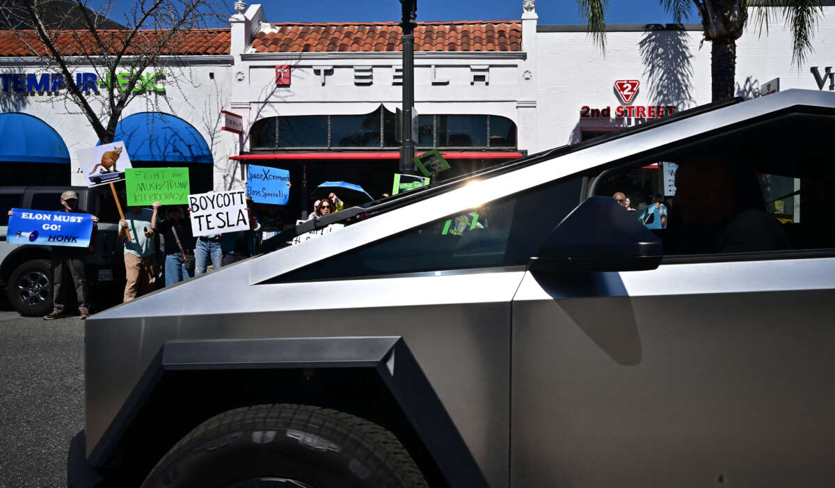 A Cybertruck is seen in front as people participate in a 'Tesla Takedown' protest against Elon Musk outside a Tesla dealership in Pasadena, California, on March 8, 2025.