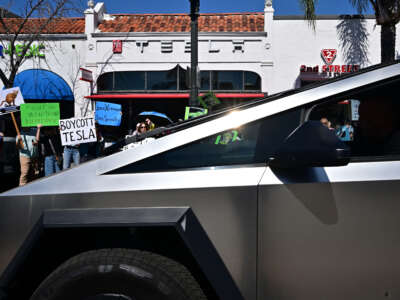 A Cybertruck is seen in front as people participate in a 'Tesla Takedown' protest against Elon Musk outside a Tesla dealership in Pasadena, California, on March 8, 2025.