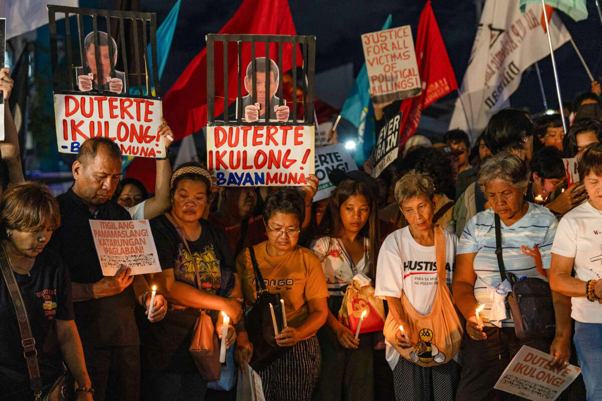 Protesters demonstrate during a candle light vigil demanding justice for drug war victims, after the arrest of former Philippine president Rodrigo Duterte, in Quezon City on March 11, 2025.