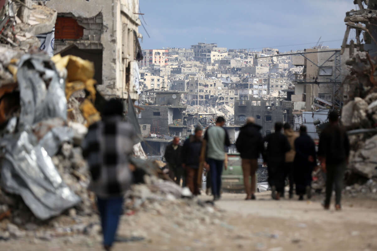 Palestinians walk amid the rubble of destroyed buildings in Jabalia, Gaza Strip, on February 21, 2025.