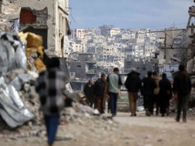 Palestinians walk amid the rubble of destroyed buildings in Jabalia, Gaza Strip, on February 21, 2025.