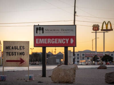 Signs point the way to measles testing in the parking lot of the Seminole Hospital District across from Wigwam Stadium on February 27, 2025, in Seminole, Texas.