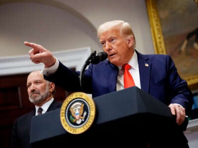 President Donald Trump, accompanied by Commerce Secretary Howard Lutnick (left) takes a question from a reporter in the Roosevelt Room of the White House on March 3, 2025, in Washington, D.C.