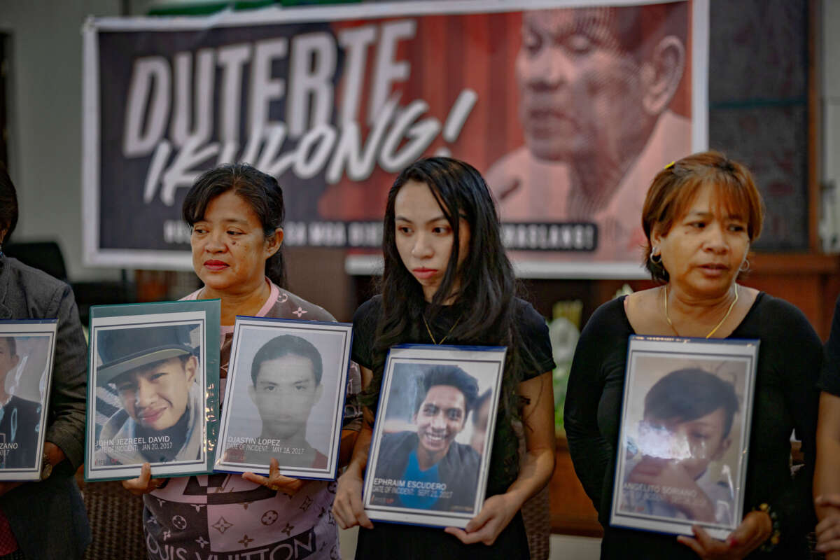 Relatives of drug war victims hold pictures of their loved ones during a gathering on March 12, 2025, in Quezon City, Metro Manila, Philippines.