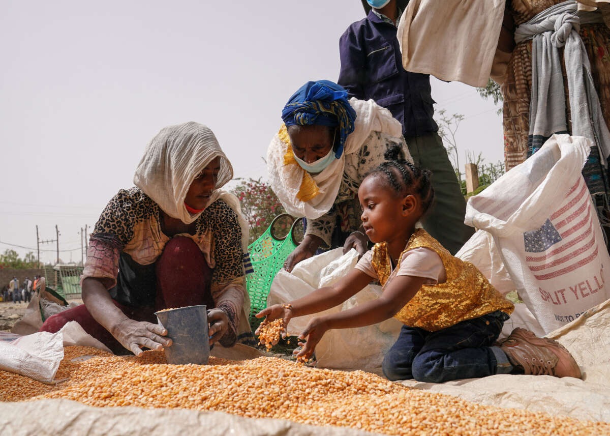 An aid worker distributes measured portions of yellow lentils to residents of Geha subcity at an aid operation run by USAID, Catholic Relief Services and the Relief Society of Tigray on June 16, 2021, in Mekele, Ethiopia.