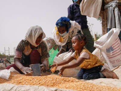 An aid worker distributes measured portions of yellow lentils to residents of Geha subcity at an aid operation run by USAID, Catholic Relief Services and the Relief Society of Tigray on June 16, 2021, in Mekele, Ethiopia.