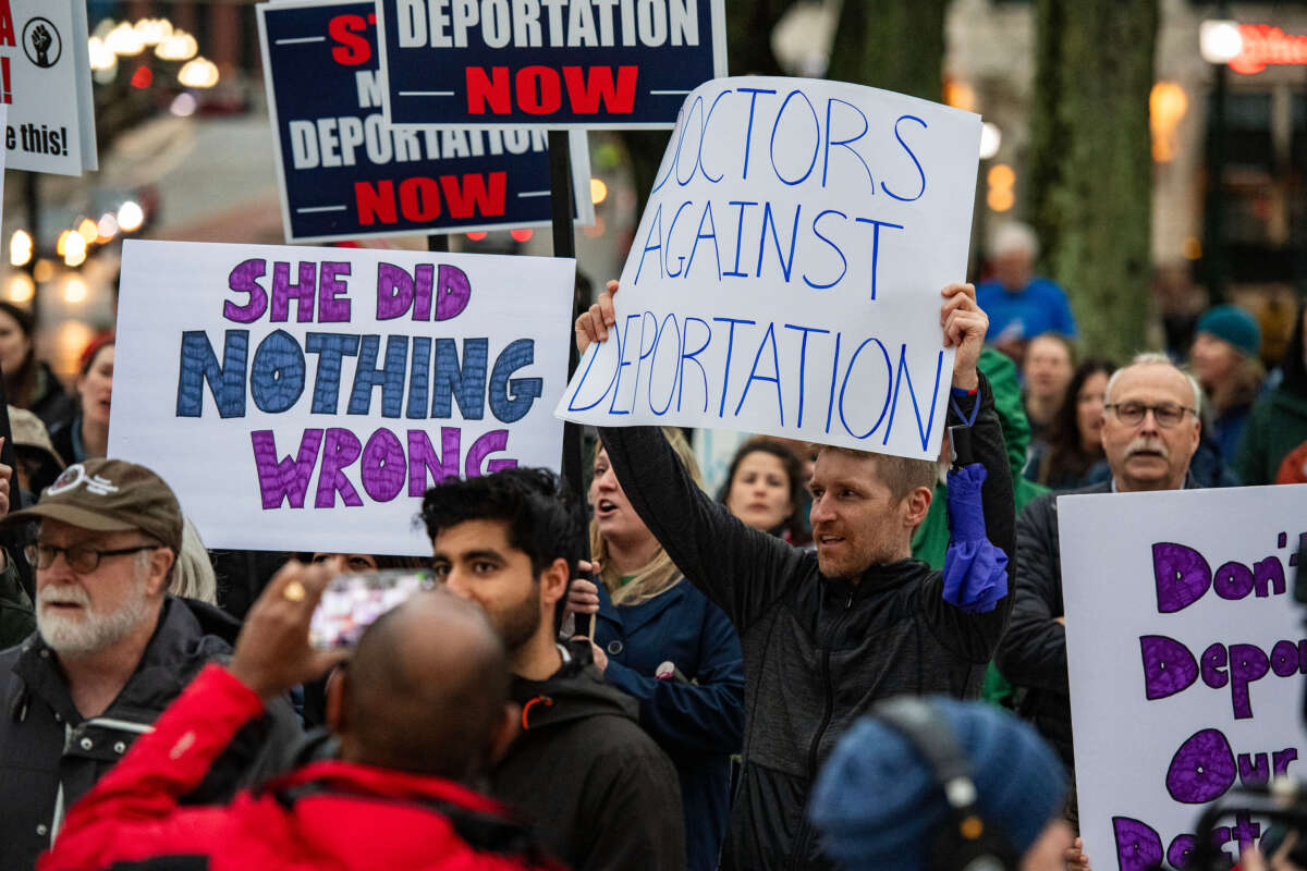 Demonstrators hold signs as they protest the deportation of Assistant Professor of Medicine Dr. Rasha Alawieh of Brown University at the State House in Providence, Rhode Island, on March 17, 2025.