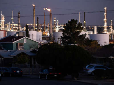 Flaring towers stand on the horizon at the Marathon Petroleum Corp. El Paso oil refinery behind a neighborhood of homes in East-Central El Paso on December 10, 2021, in El Paso, Texas.