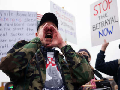 A man shouts through cupped hands during an outdoor protest