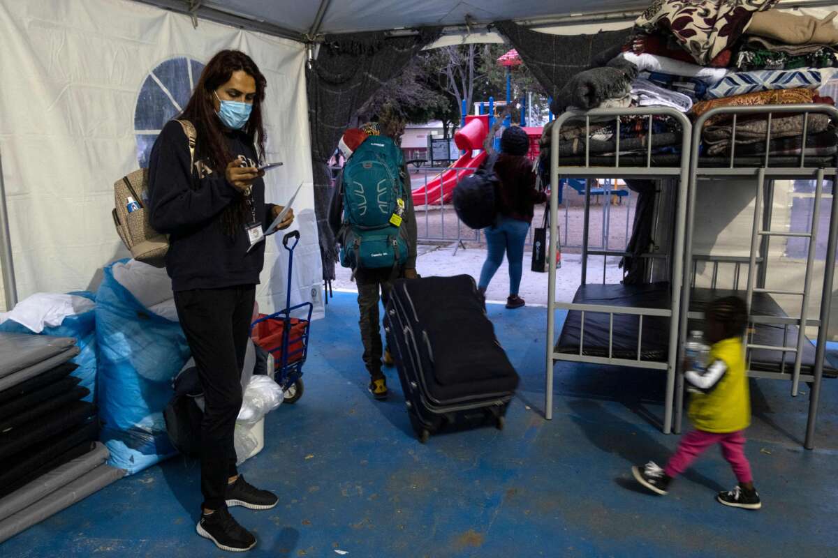 Mexican Brigitte Baltazar Lujano, a 35 year-old transgender woman, checks her mobile phone as asylum seekers leave a shelter to take a bus to the crossing port to enter the U.S. under humanitarian parole, in Tijuana, Baja California state, Mexico, on June 8, 2022. - Deported last year from the US after living there for 18 years and asylum seeker fleeing from violence herself, Brigitte now works for Al Otro Lado, an organization that provides legal and humanitarian support to refugees, deportees, and other migrants in the US and Tijuana.