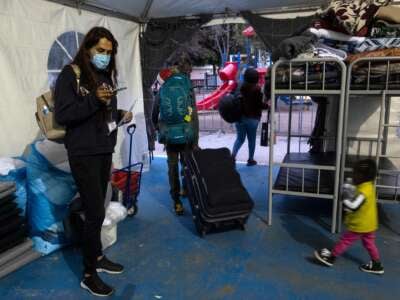 Mexican Brigitte Baltazar Lujano, a 35 year-old transgender woman, checks her mobile phone as asylum seekers leave a shelter to take a bus to the crossing port to enter the U.S. under humanitarian parole, in Tijuana, Baja California state, Mexico, on June 8, 2022. - Deported last year from the US after living there for 18 years and asylum seeker fleeing from violence herself, Brigitte now works for Al Otro Lado, an organization that provides legal and humanitarian support to refugees, deportees, and other migrants in the US and Tijuana.