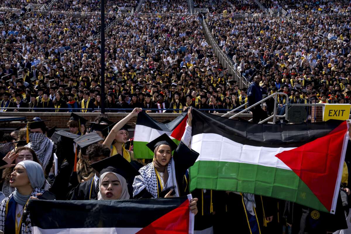 Salma Hamamy, center, holds a flag of Palestine during the University of Michigan's spring commencement ceremony on May 4, 2024, at Michigan Stadium in Ann Arbor, Michigan.