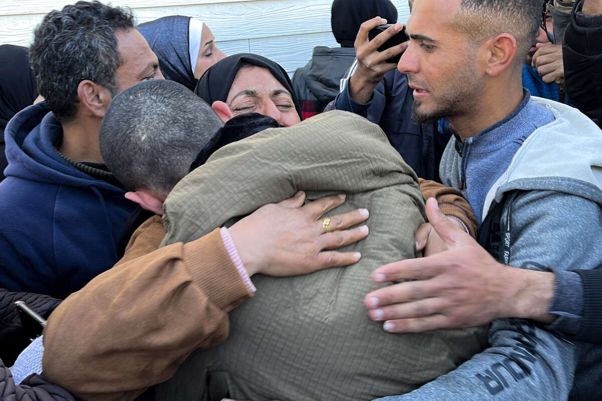 A Palestinian prisoner is embraced by a member of his family at the European Hospital in Khan Yunis in the southern Gaza Strip on February 27, 2025, following his release by Israeli authorities.