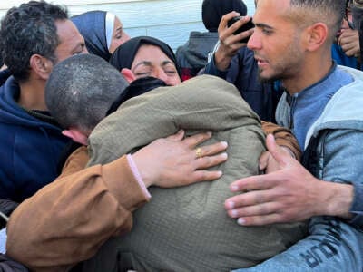 A Palestinian prisoner is embraced by a member of his family at the European Hospital in Khan Yunis in the southern Gaza Strip on February 27, 2025, following his release by Israeli authorities.