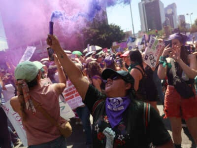 A demonstrator lights a flare during an International Women's Day march in Mexico City on March 8, 2025.