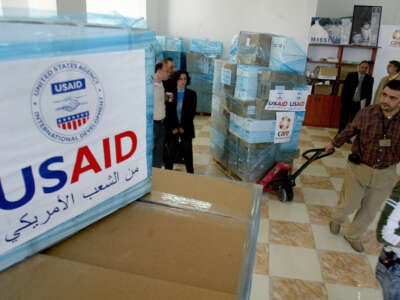 U.S. Agency for International Development employees are seen at the CARE international warehouse in the West Bank town of Ramallah, on May 10, 2006, as they ready to load two trucks with donated medical supplies to be sent to the Gaza Strip.