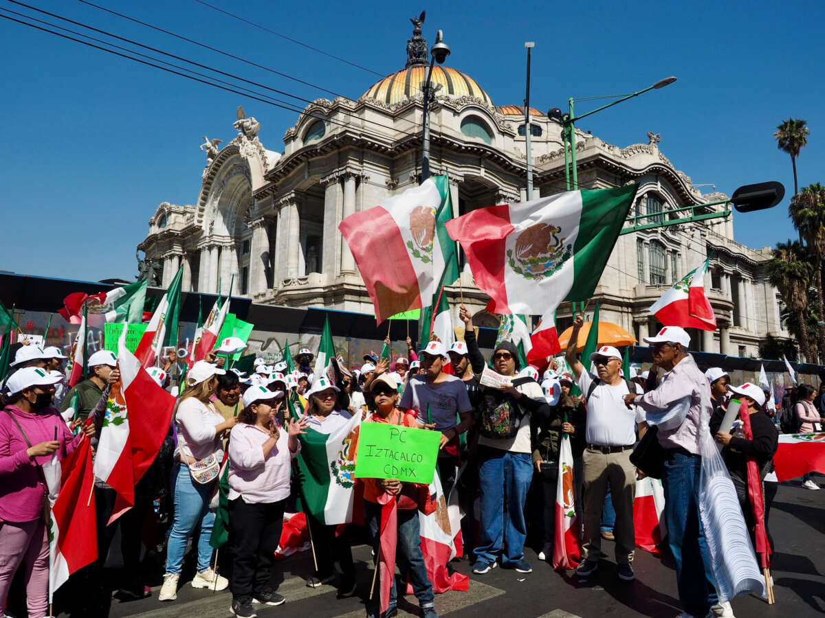 Demonstrators pose while waving the Mexican flags in front of the Palace of Fine Arts in Mexico City on Sunday, March 9, 2025.