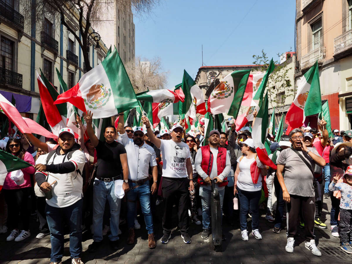 Demonstrators wave the Mexican flag while marching on Avenida 5 de Mayo in Mexico City on March 9, 2025.