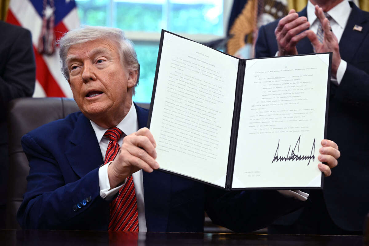 Donald Trump holds up an executive order