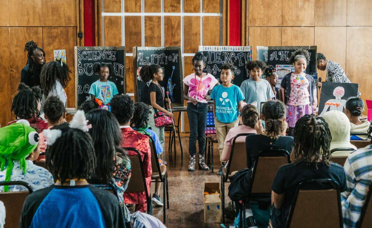 Students present their science fair projects to an audience, exploring topics from pollution to human anatomy at For the Culture in San Antonio, Texas.
