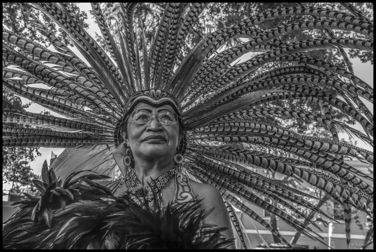 Un miembro mayor de Grupo Calpully Xochilyauhtli (Casa Flor Santa María) lleva su tocado de plumas.