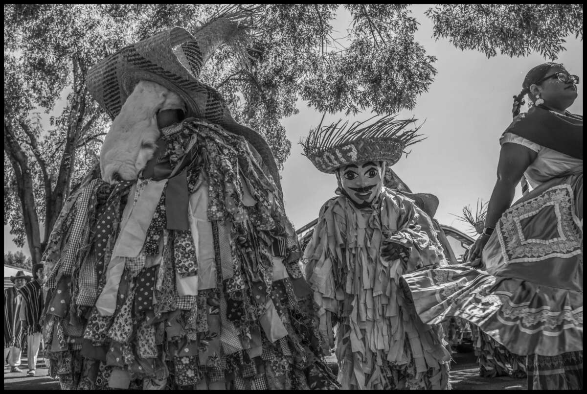 Dos artistas del Comite Pochtlan del condado de Sonoma, un grupo local de activistas culturales, usan trajes de los Viejos de Putla Villa de Guerrero.