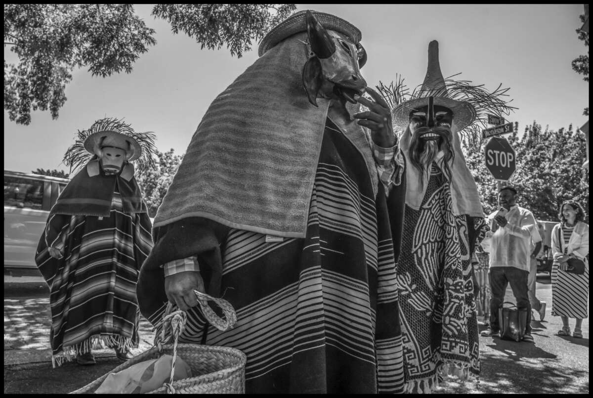 Los miembros del Comite Pochtlan del condado de Sonoma usan trajes para realizar los comparados del Viejos de Putla Villa de Guerrero.